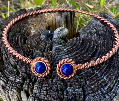 Copper and blue stone earrings on a textured wooden surface