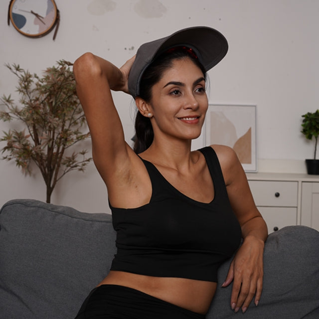 Red Light Therapy Hat on woman smiling and sitting on couch