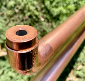 Close-up of a brass fitting with a green grass background