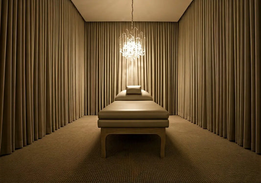 Luxurious med bed in a wellness spa room with soft lighting and elegant chandelier