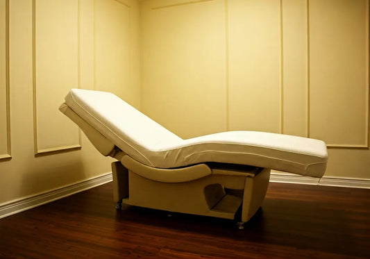 Adjustable med bed in a spa room with beige walls and wood flooring, wellness technology