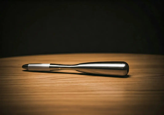 Sleek silver energy healing pen on wooden surface for frequency wellness