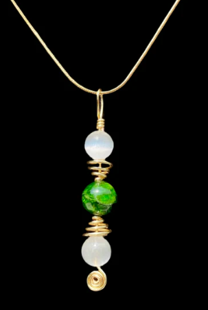 Necklace with green and white beads on a black background