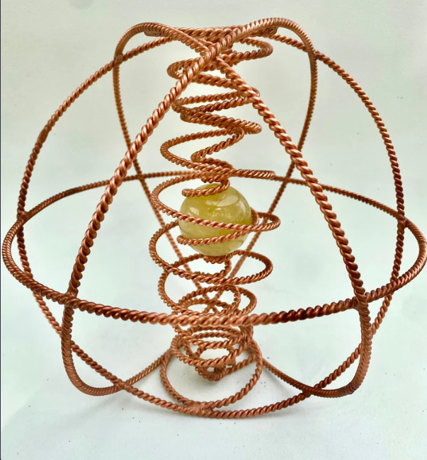 Copper coil structure with a central sphere on a white background
