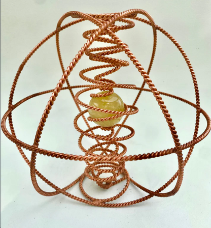Copper coil structure with a central sphere on a white background