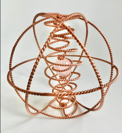 Copper coil sculpture on a white background